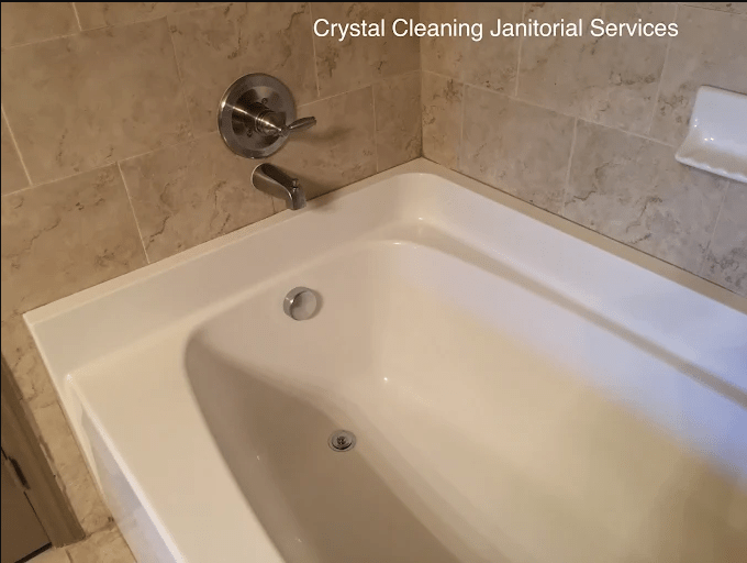 Clean bathtub with modern fixtures and tiled walls, showcasing the services offered by Crystal Cleaning Janitorial Services.