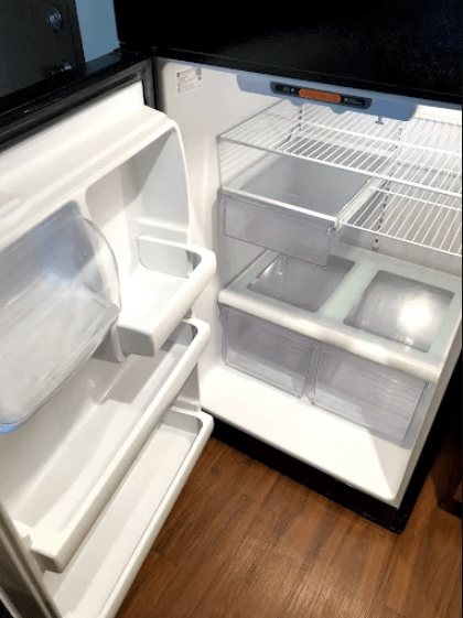 Interior view of an empty refrigerator, showcasing customizable shelves and clear drawers. Ideal for demonstrating storage options and organization.