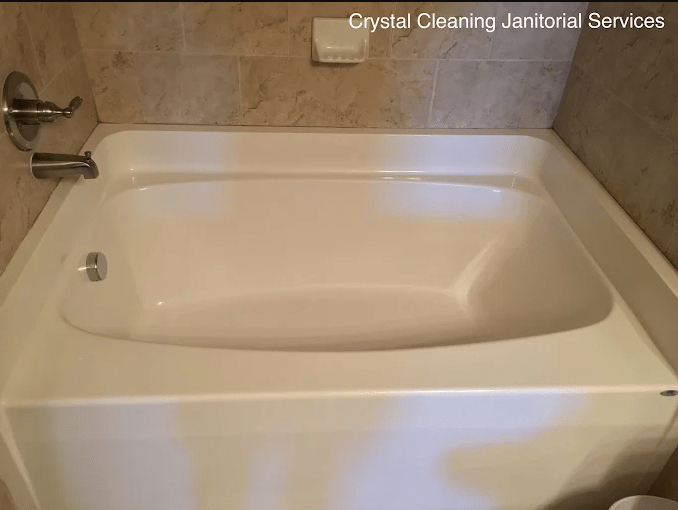 Clean, empty bathtub in a tiled bathroom, showcasing its polished surface and simple design. Highlights the effectiveness of cleaning services.