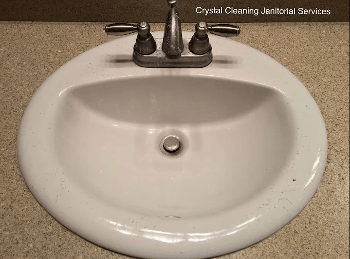Stained white sink with metal faucets, showcasing cleanliness issues relevant to Crystal Cleaning Janitorial Services.